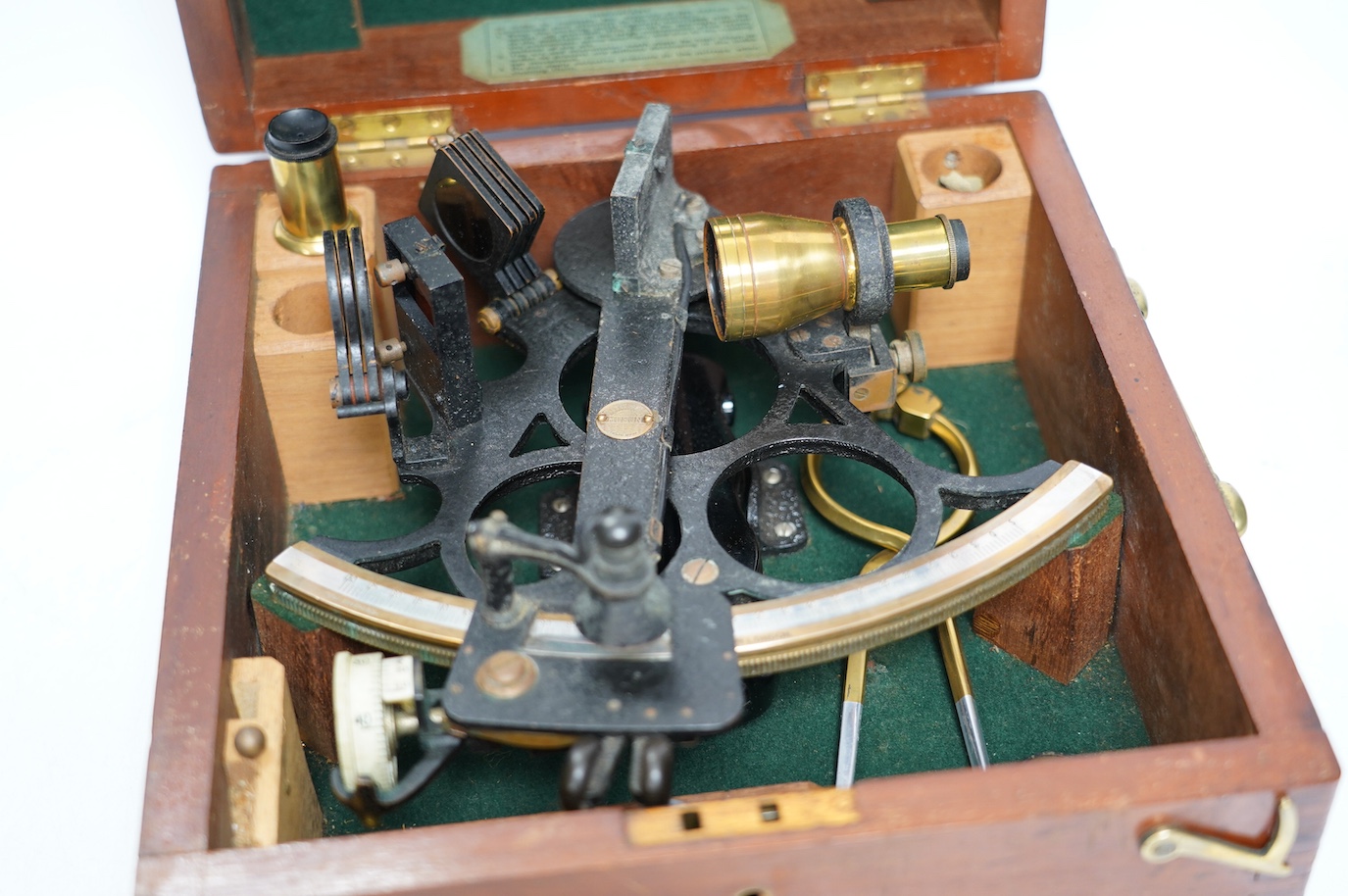 A mid 20th century sextant by Henry Hughes & Son Ltd., in a fitted mahogany case, with detailed labels to the inside of the lid. Condition - good.